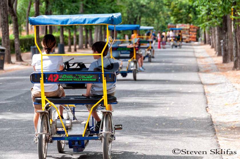 Biking through park. Villa Borghese gardens. Rome. Italy.